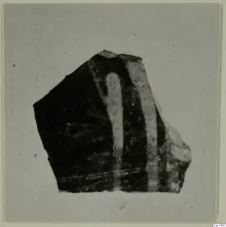 Pottery sherd with a dark surface and two pale curving bands, photographed on a grey card.