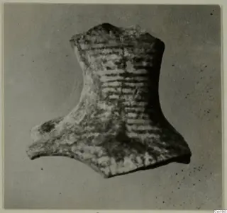 Pottery fragment with horizontal ridged bands, photographed against a grey background