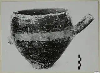Reserved Ware pottery vessel from Vounous with a tubular spout and a pale band around its body.