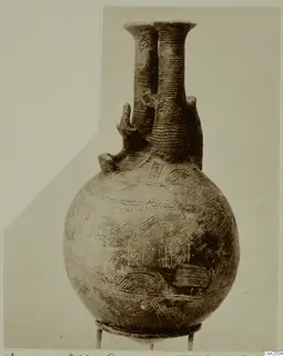 Double-necked jug from Vounous with incised chevron, arc and band decoration, shown on a small stand