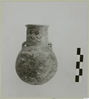 Globular pottery vessel with a short neck, two small lug handles and incised chevron and diamond patterns, beside a scale bar.