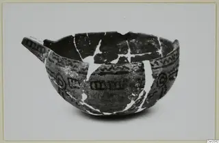 Pottery bowl with one handle, dark painted bands, zigzags and concentric circles, its breaks joined with pale lines