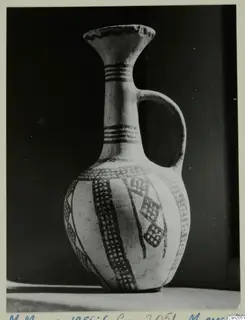 Pottery White Slip Ware jug with cross-hatched painted bands, photographed against a dark background