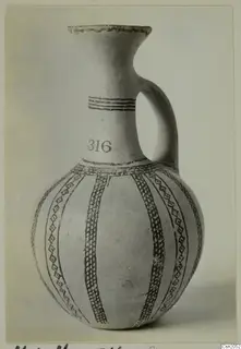 Jug with a single strap handle, white slip and dark painted bands and lattice panels, with the number 316 on the neck.