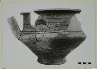 Pottery Monochrome Ware vessel from Marion with a tubular spout and flaring rim, broken and partly pieced together.