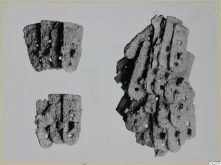 Three corroded iron fragments with raised parallel ridges and small round holes, on a plain pale background.