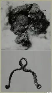 Corroded metal objects: an encrusted mass above and a looped, hooked metal piece below.