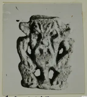 Small flat object with raised relief and four holes, photographed on a card mount, Ayia Irini finds