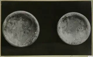Two blown glass bowls seen from above against a dark background.