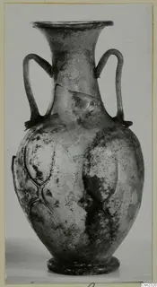 Small blown glass two-handled vessel with a pattern of raised lobes on the body.