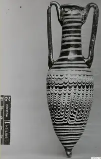 Sand-core glass two-handled vessel with white and dark trailed stripes and a feather-like pattern on the body.