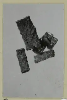 Iron tools and tool parts: several corroded, rectangular metal pieces on a pale background