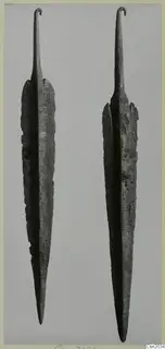 Two long corroded metal blades with hooked tangs, shown side by side against a grey background