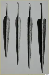Four leaf-shaped metal blades with hooked tangs, shown upright side by side.