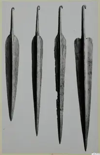 Four long metal blades with hooked tangs, laid out in a row on a grey background