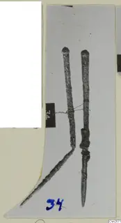 Two corroded bronze tools bound together with fine wire, shown on a mounted photograph card