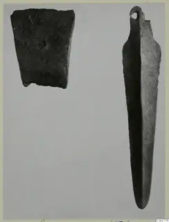 Two bronze tools on a grey background: a corroded rectangular fragment and a long, narrow tool with a loop at one end.
