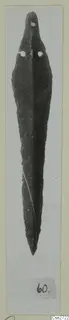 Long narrow bronze blade with a pointed tip and two rivet holes near the top, photographed on a card mount