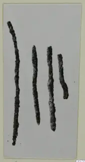 Four corroded metal rods, probably bronze tools, shown side by side on a pale background, from Milia