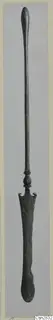 Long bronze implement with a rounded top end, a knob collar and a flat, spatula-like blade at the lower end.