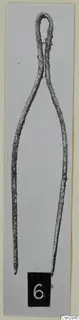 Pair of corroded metal tongs with a looped top, shown upright with a number label.