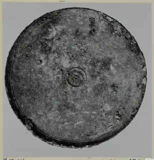 Bronze mirror from Marion, tombs 46–60, seen as a round disc with a central boss