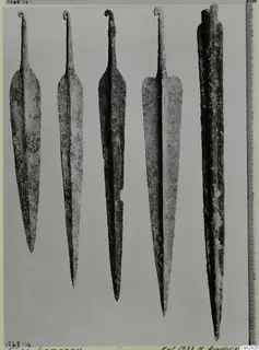 Five corroded metal points with curled tangs, shown side by side before conservation