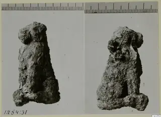 Two views of a small, heavily encrusted figure-like object, with a scale ruler along the top edge