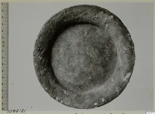 Shallow round bowl with a thick rim, seen from above, beside a graduated ruler.