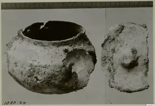 Pottery bowl with a broken rim beside a sherd with a central knob, photographed next to a scale ruler.