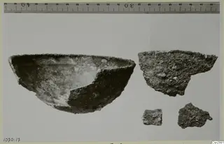 Bowl and three sherds laid out on a plain background, with a measuring ruler along the top edge