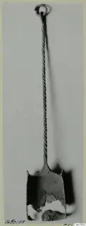 Corroded metal object with a ring at the top, a long twisted shank and a broken cup-shaped end, before conservation