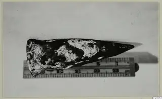 Iron moil, a pointed iron tool with corroded patches, lying beside a measuring ruler for scale