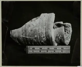Fragments of a clay pipe found in an ancient working, photographed beside a folding ruler