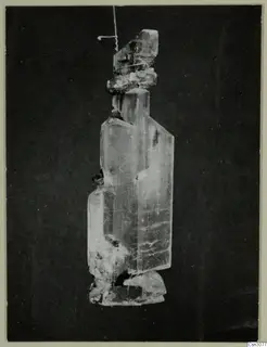 Selenite crystal from the Skouriotissa mine, hanging by a thread against a dark background