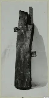 Weathered wooden timber with two short side projections, shown beside a metal ruler
