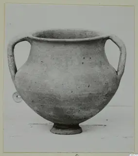 Two-handled pottery jar with a wide mouth and footed base, photographed against a plain background.