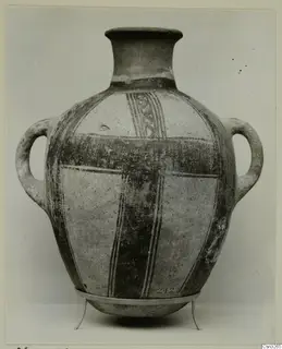 Two-handled White Painted pottery jar with a tall flaring neck and dark painted bands, standing on a metal stand