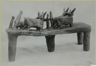 Terracotta model of a rectangular stand on four legs, with several horned animal figures and upright posts on its top