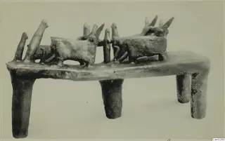 Terracotta stand on four tubular legs, carrying two horned animal figures and several upright pegs