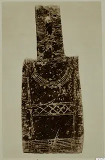 Flat figure-shaped terracotta idol with a narrow upper part and incised arcs, lattice and bands on the body