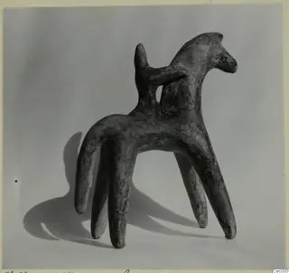 Terracotta figurine of an animal with four long legs and a raised head