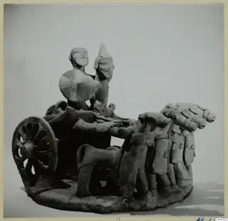 Terracotta model of a two-wheeled chariot carrying two standing figures, drawn by a team of animals