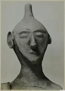 Terracotta statuette from Ayia Irini, head and shoulders with a tall cylindrical top and stylised face