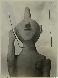 Terracotta statuette from Ayia Irini, front view of head and upper body with one arm raised