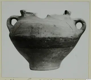 Wheel-made pottery vessel with two loop handles and a broken rim, from Milia