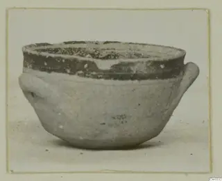 Small bowl with two side handles and a dark painted band around the upper body and rim.