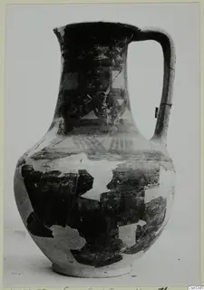 Jug with a single loop handle and dark painted bands and geometric patterns, shown against a plain background