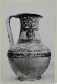 Painted pottery jug with a strap handle, decorated with bands, triangles and spiral motifs in dark paint on a light body.