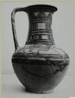 Painted pottery jug with a strap handle and geometric panels on its neck